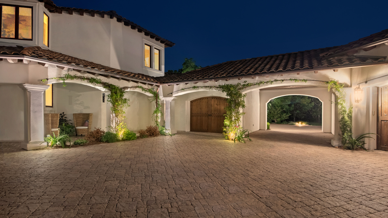 An evening shot from a mansion's courtyard, showing the effect of residential landscape lighting