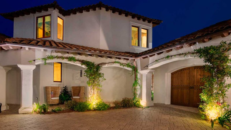 Mansion lit under the evening sky, contrasting with the glow of outdoor home accent lighting