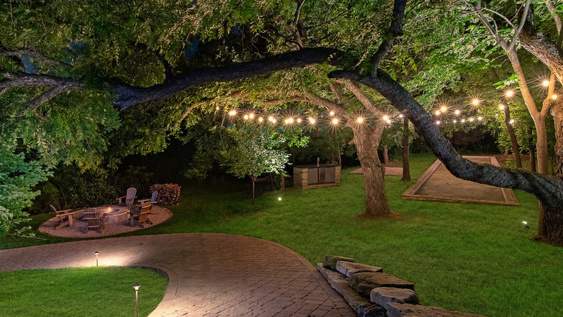 A garden scene with a walkway, illuminated by the excellence of outdoor led lighting